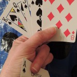hand holding cards with an ace in the sleeve
