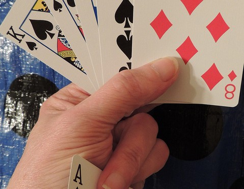 hand holding cards with an ace in the sleeve