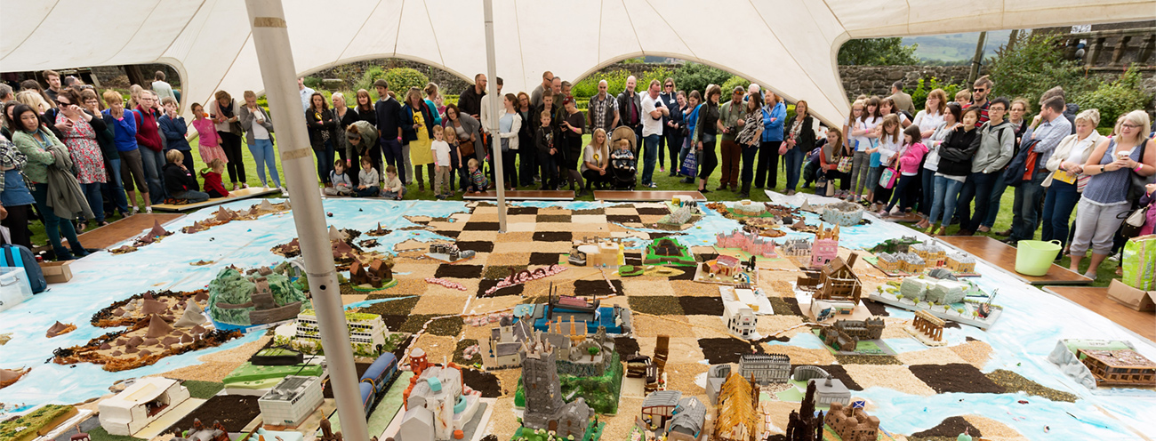 crowds look onto a display of model cakes